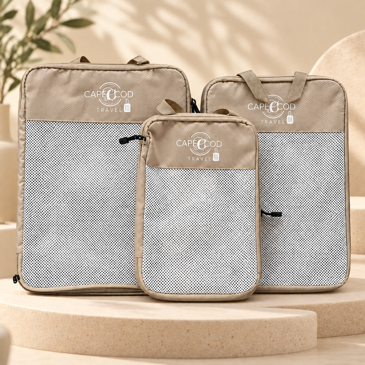 Dreiteiliges Kompressions-Packwürfel-Set in Beige auf warmem beigem Studiohintergrund